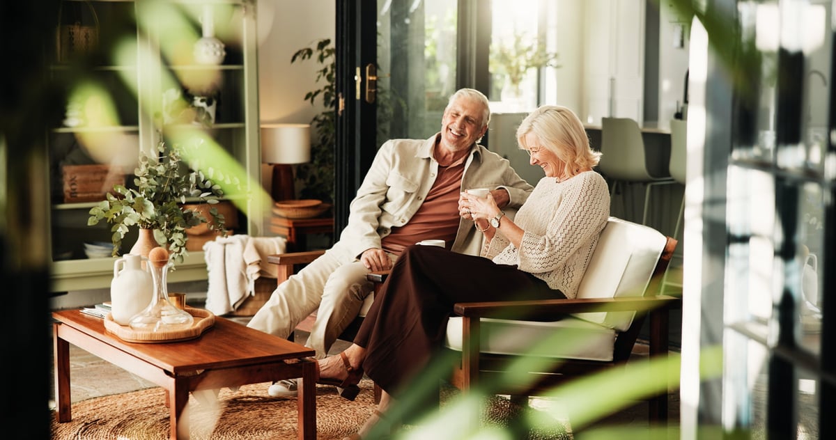 Pareja de 60 años sonriendo y disfrutando de su tiempo juntos en casa